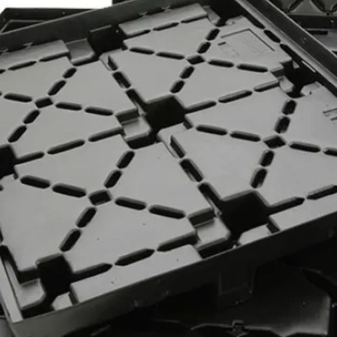 Black molded plastic pallet base with a repeating rib pattern