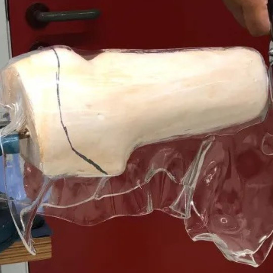 White wrapped form held during a drape-forming process